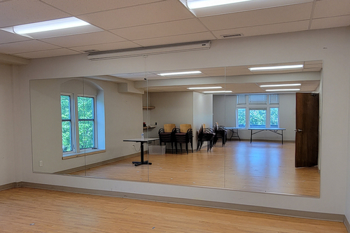 A photo of a large custom glass mirror in a dance studio.