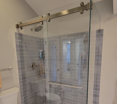 Photo of a barn style sliding shower door in an Ann Arbor bathroom remodel.