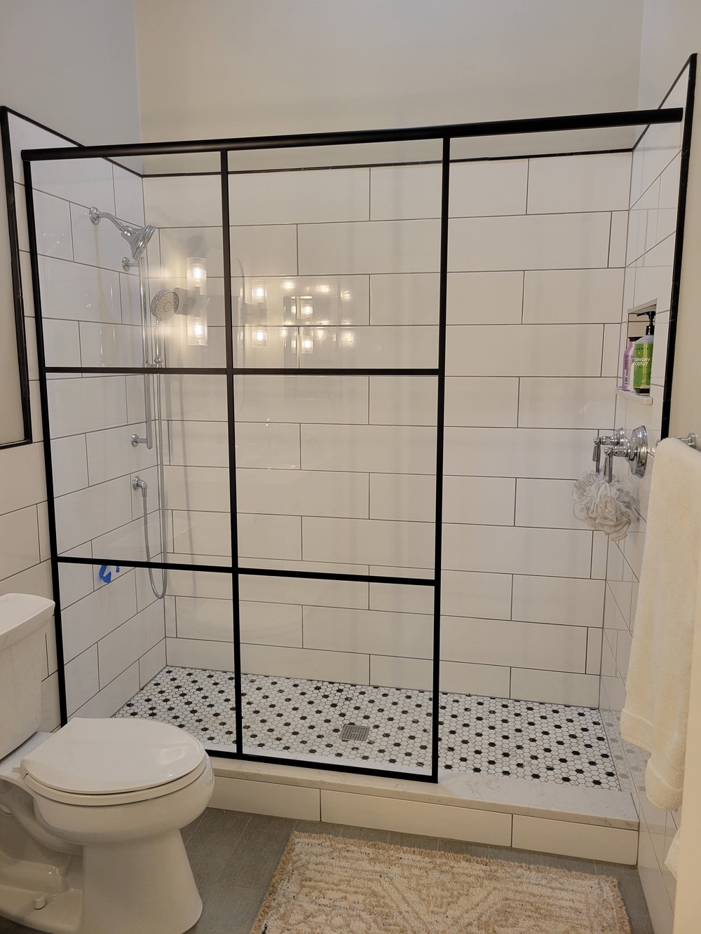 Frameless shower panel with Matte Black Vista Grid and Low Iron Glass
