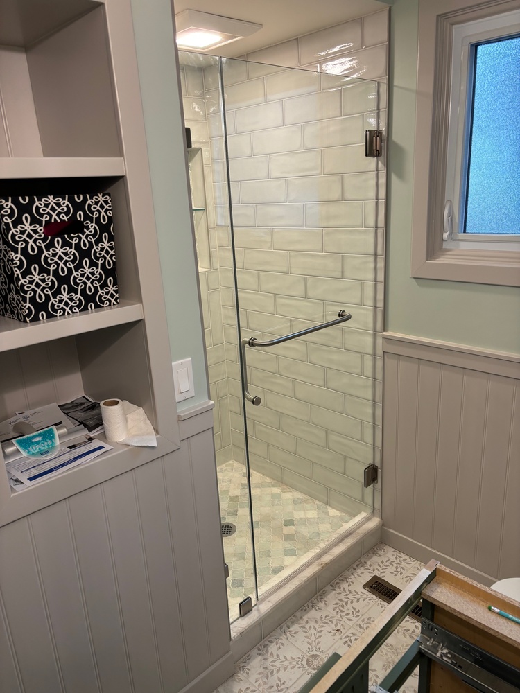  - Frameless shower door and panel with brushed nickel hardware, clips, and towel bar/handle combo.